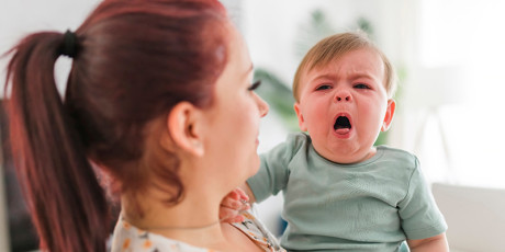 Hoestend kindje op de arm van een vrouw