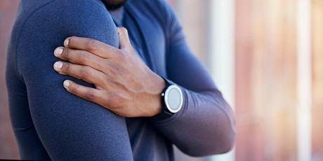 man grijpt naar schouder