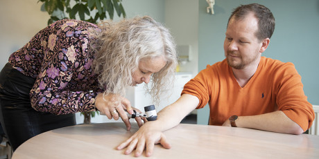 Huisarts bekijkt verdachte plek op onderarm patiënt