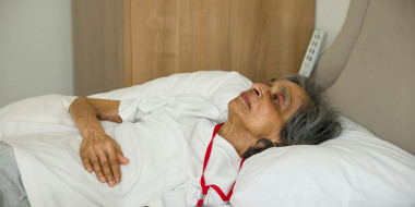 Oudere vrouw op bed