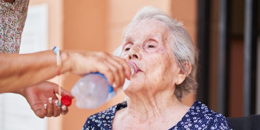Oude vrouw neemt een slok water