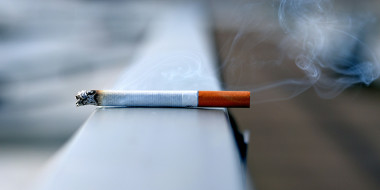 Brandende sigaret op een balkonrailing